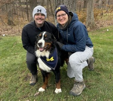 Robert Humble with husband Anthony and dog Rooster on a wooded trail.
